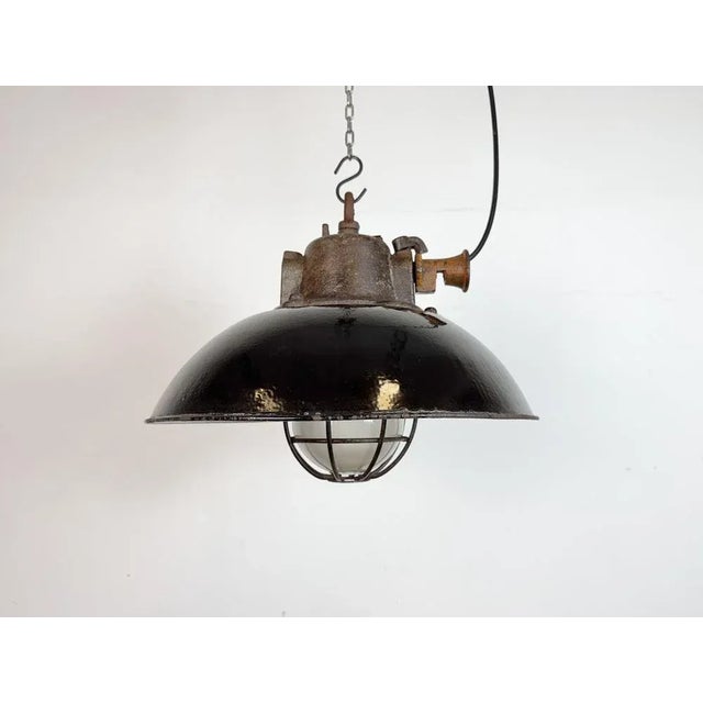 Industrial hanging lamp manufactured by Elektrosvit in former Czechoslovakia during the 1960s. It features a black enamel...