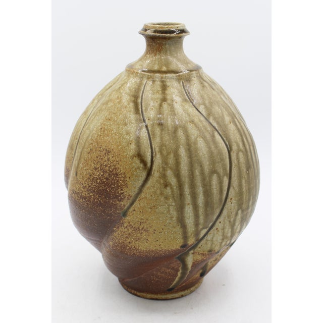 Swirlled body pottery vase by Ben Owen III, 1994. Richly striated drip glaze with incised lines setting off the swirlled,...