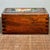 A carved hardwood sliding drawer box with a richly detailed front panel inlaid in bone, depicting an auspicious mythical...