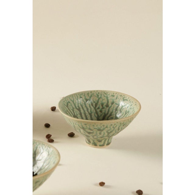A set of two Japanese-style ceramic bowls; the glaze features a vein-like pattern, with a soft and understated color palette.