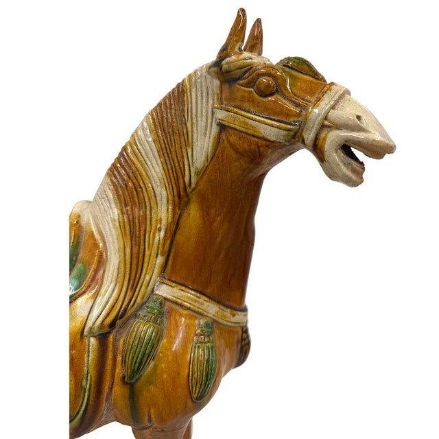 A large vintage Tang style Sancai glazed terracotta horse. This exquisite piece features a striking green and brown color...