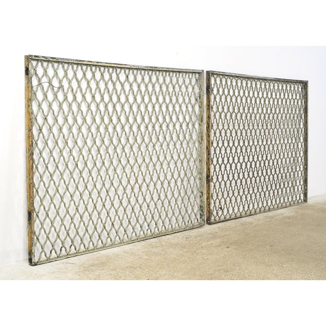 Industrial style tan and gray painted steel security panels made of woven wire in a diamond pattern with a rectangular...