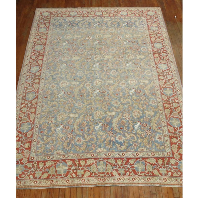 A room size Persian wool and silk highlight Persian Qum rug from the early 20th century. Powder blue field and red border