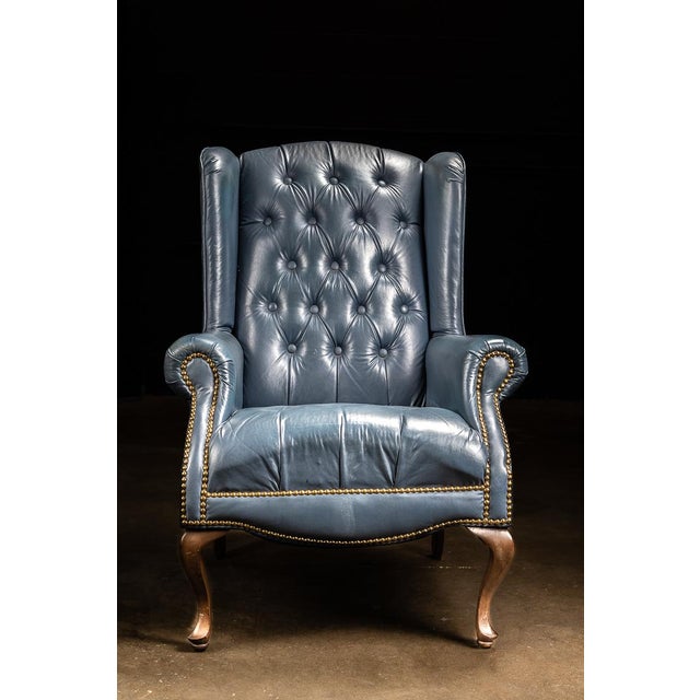 This vintage armchair features tufted leather and wooden construction. The chair is sturdy and ready for decades more use.