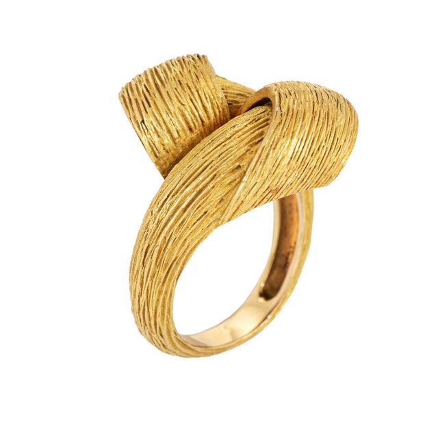 Stylish infinity knot ring designed by French jeweler Robert Duhem crafted in 18 karat yellow gold (circa 1960s). The ring...
