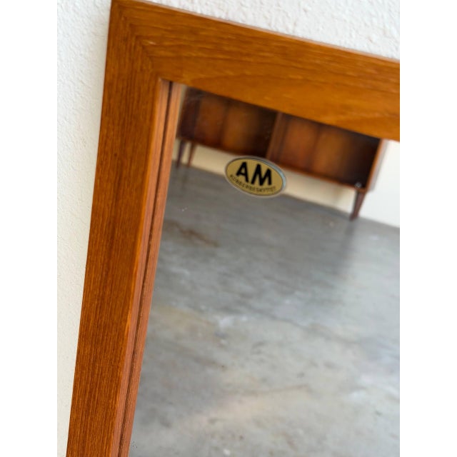 Danish wall mirror crafted in solid teak, featuring a clean rectangular form and warm natural wood grain. The minimalist...