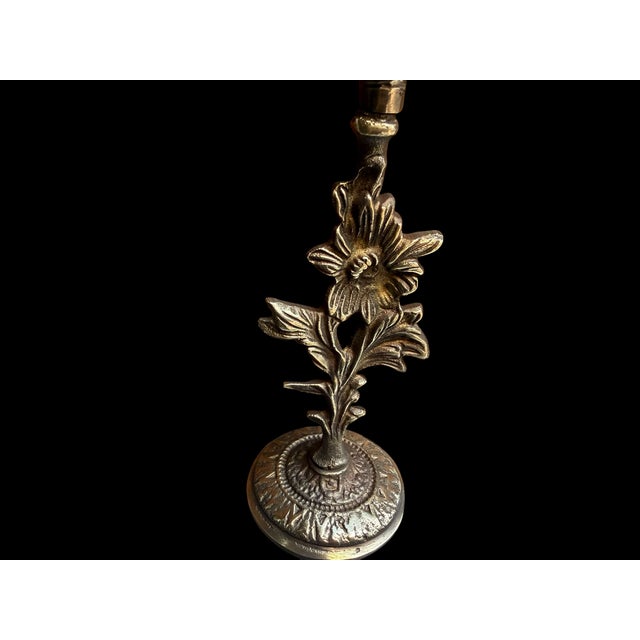 A handmade brass candlestick pair with a sculptural floral stem, petal-edged candle cups, and round embossed bases. The...