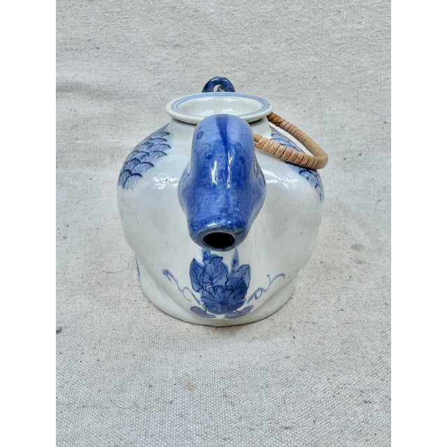 Fun vintage chinoiserie teapot. Ceramic. Blue and white detailing. Wrapped wicker handle. Meant to be a decorative piece....