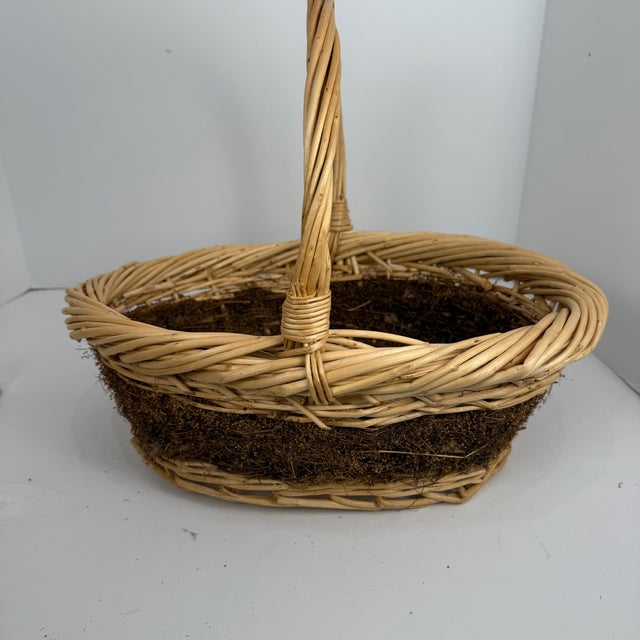 This was hanging in my mothers kitchen , early 1980's-ish. It is a sturdy light natural color wicker with a green/brown...