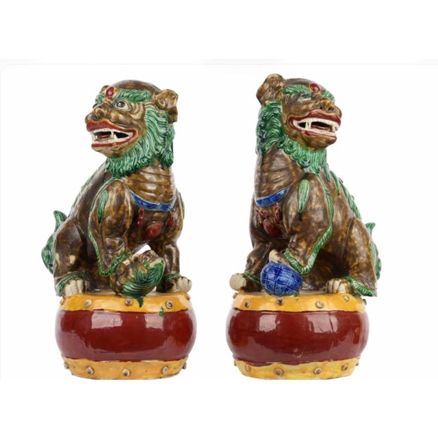 Pair of Male and Female Polychrome Sancai Glazed Ceramic Figures of Foo Dogs. The mythical guardian beasts are depicted...