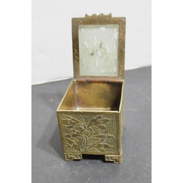 Antique early 20th-century Chinese brass engraved outside and inside the box, stamp box. Jade panel top on hinged lid. The...