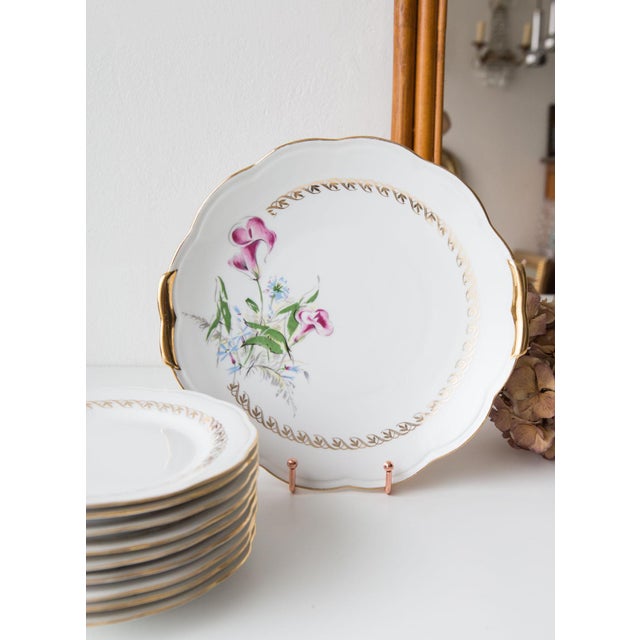 The set is composed by 9 pieces: 1 serving dish and 8 dessert plates. Dimensions: ⌀ 19 cm (plates), 28*26,5 cm (dish).