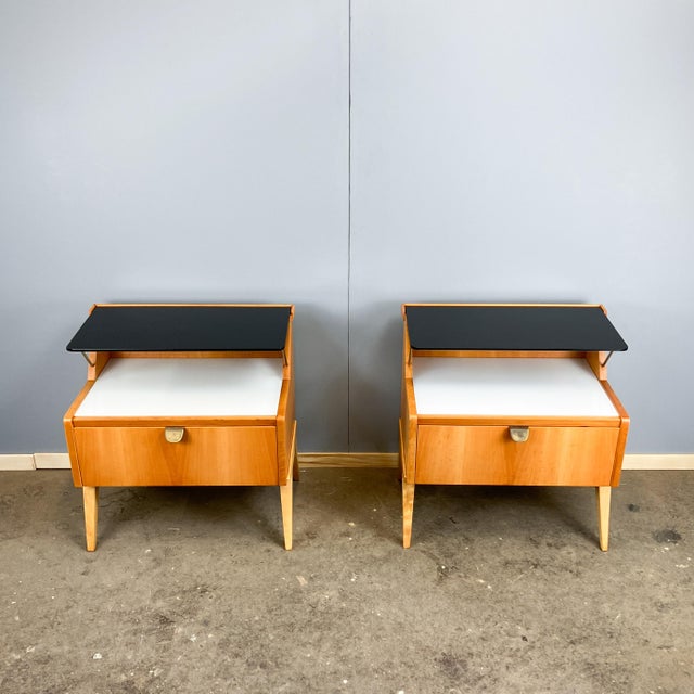 A beautiful pair of bedside tables from the german workshop for interior design, whose distinctive style evokes the 1950s....