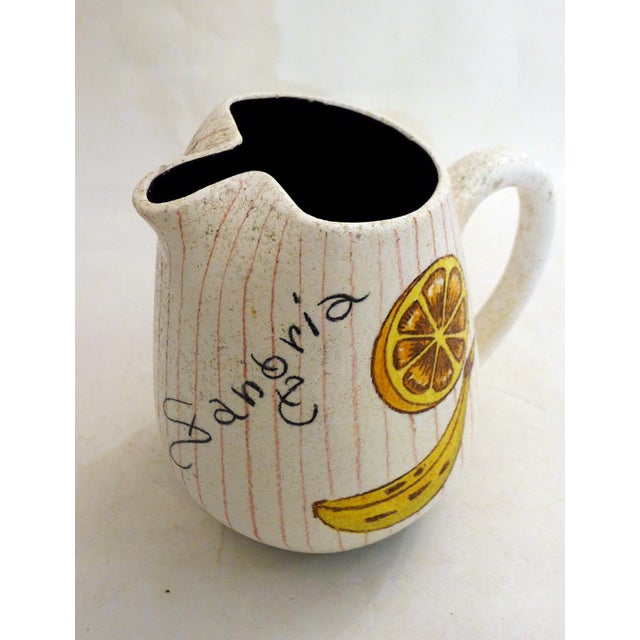 Large mid-century sangria pitcher, rounded body with a spout folded into the shape and a tubular handle, decorated with a...