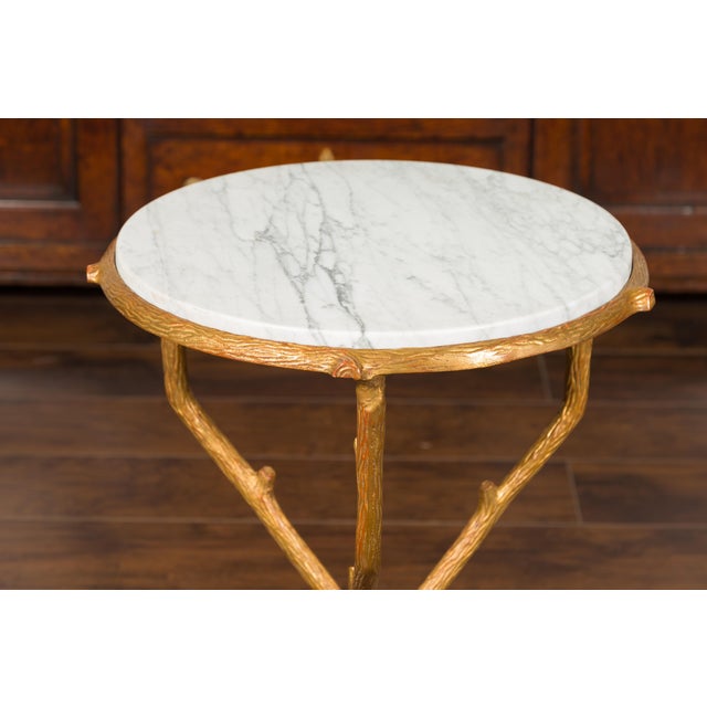 A French vintage gilt metal faux-bois inspired side table from the mid-20th century, with white veined marble top. Created...