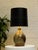 A handsome vintage table lamp featuring a rounded, substantial base with an earthy glazed finish. Layers of warm brown,...