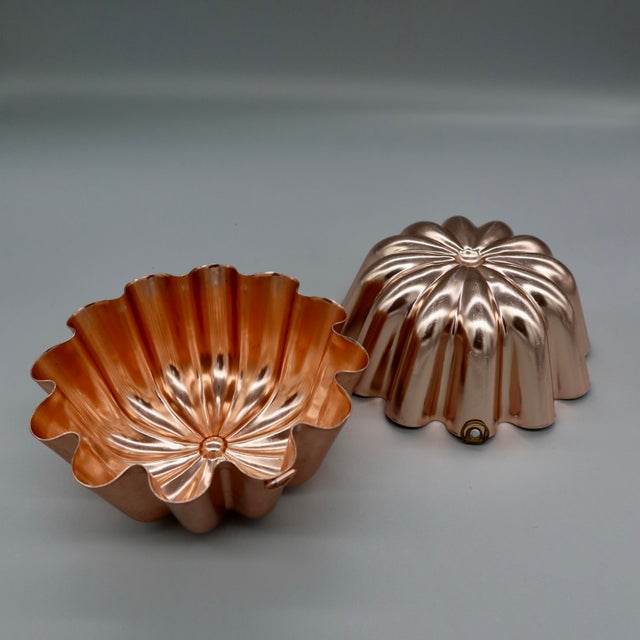 A charming near-pair of vintage copper molds in a scalloped marguerite/daisy pattern. One is stamped "3½ CUPS," and both...