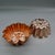 A charming near-pair of vintage copper molds in a scalloped marguerite/daisy pattern. One is stamped "3½ CUPS," and both...