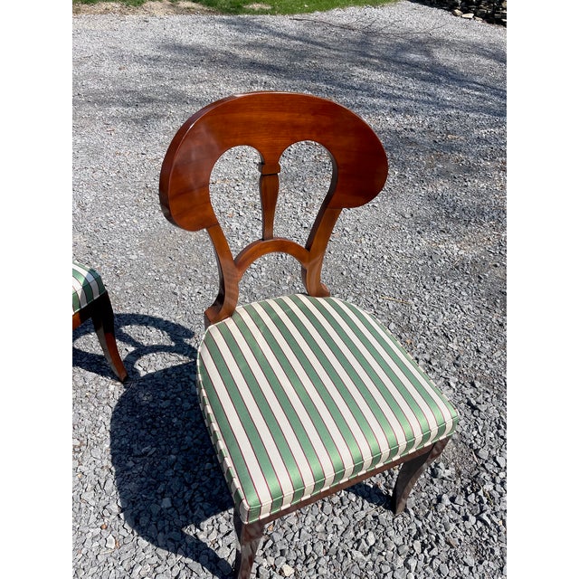 Four Art Deco-style mahogany dining side chairs by John Widdicomb Furniture. These classic Biedermeier style chairs are...