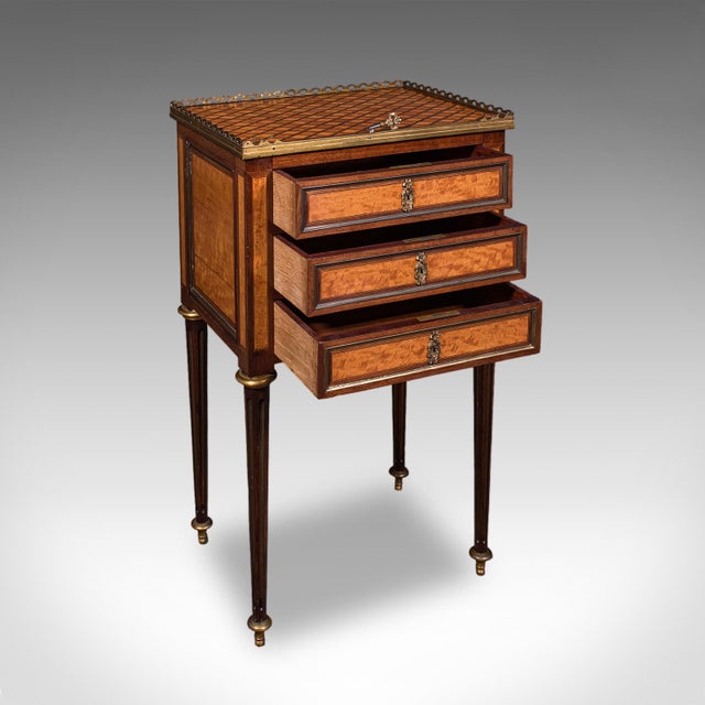 This is an antique nightstand. A French, walnut and satinwood set of bedside drawers in Louis XVI taste, dating to the...