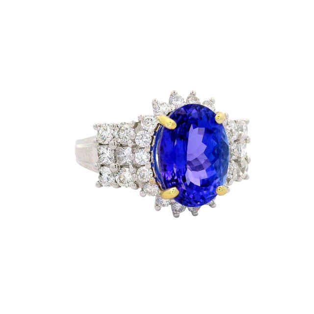A striking fashion ring featuring a central 3.90 carat oval tanzanite with a vivid blue hue. Encircling the centerpiece...