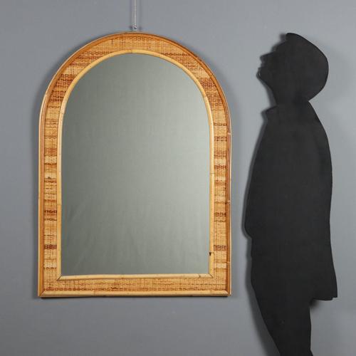 Arched mirror with wicker and bamboo frame. This piece is attributed to the mentioned designer/maker. It has no...