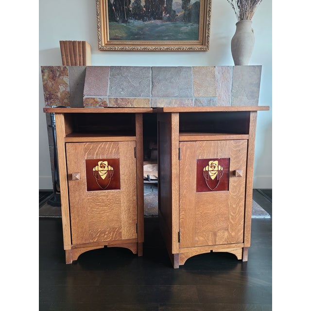 Two mission nightstands in the style of Stickley. Crafted from oak. Square top over an open shelf and cabinet door. One is...