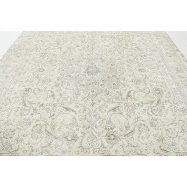 Made with hand-knotted wool and originating circa 1970-1980, this 10x10 vintage Tabriz rug represents a distinguished...