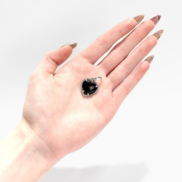 A fine signed silver & onyx pendant. By David Yurman. In sterling silver. With a faceted onyx prong-set in a textured...