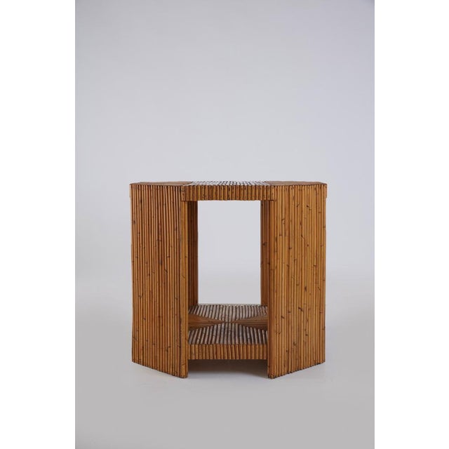 rare vintage 1970s octagonal-shaped table with wooden structure and rattan covering, equipped with small wheels under the...