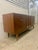 This mid-century modern credenza is a United Furniture piece featuring a walnut finish and characteristic tapered legs....