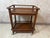 A charming rolling wooden serving cart dating from the 1940s, with clean, geometric lines. Its warm brown hue highlights...