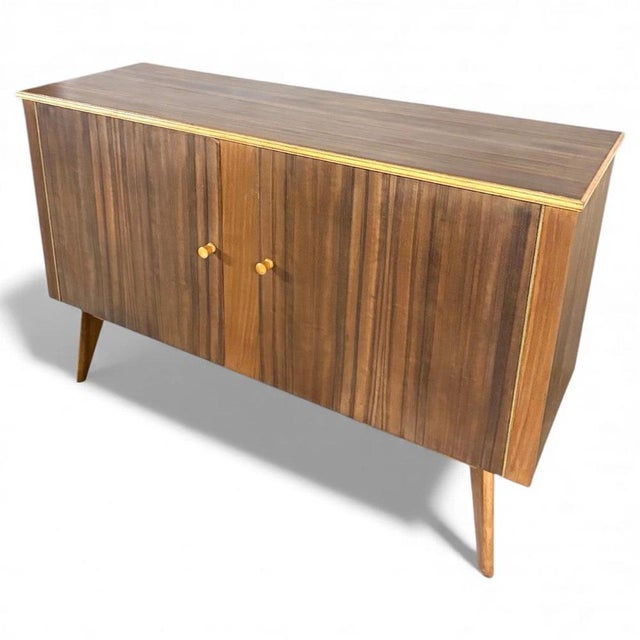 This mid century sideboard by Morris of Glasgow is a refined storage unit that combines elegant walnut veneer...