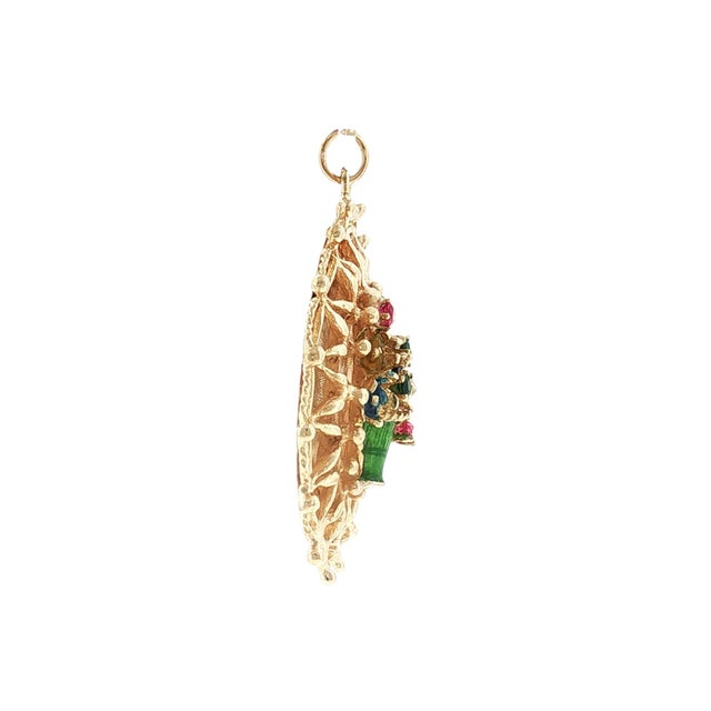 A 1960's 14k gold charm featuring a floral basket design with enameled flowers. The charm is adorned with round red...