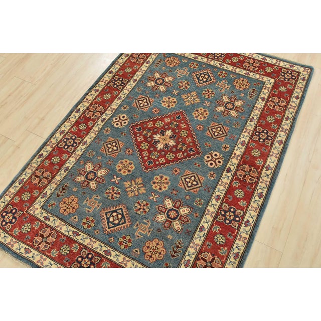 A tribal Caucasian Kazak rug hand-knotted with an all-wool pile on a cotton foundation. This oriental rug features a...