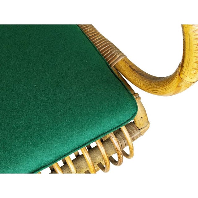 This beautiful pair of rattan and rush armchairs was produced in Italy around 1960. One armchair show few rattan losses at...