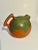 A wonderful hand crafted pottery terra cotta pitcher with earthenware color and a green accent. The pitcher is round with...