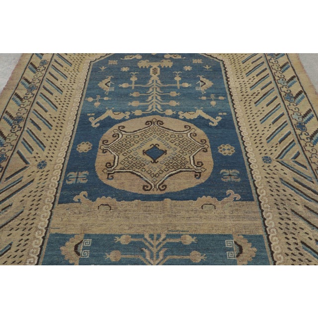 Made with hand-knotted wool, this 6x14 vintage Khotan runner rug, originating circa 1950-1960 from East Turkestan, is a...