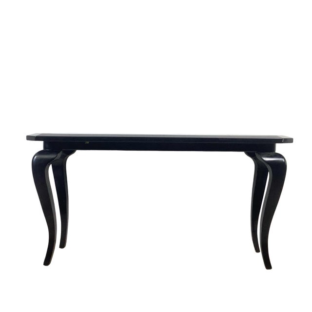 This is postmodern furniture at its most theatrical — a glossy black lacquer console table with a faceted, canted-corner...