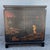 A charming vintage Chinese dry bar featuring a black lacquered finish with hand-painted landscape scenes in warm red,...