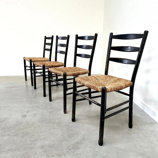 Set of 4 mid century dining chairs made of black lacquered wood with wicker seats. Solid and overall in good vintage...