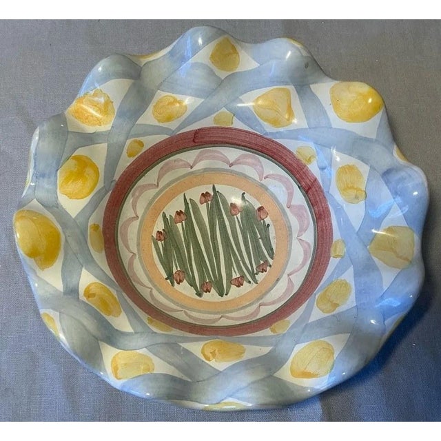 A retired MacKenzie-Childs Aalsmeer pattern bowl with a ruffled rim, hand-painted in soft blue lattice and yellow dots...