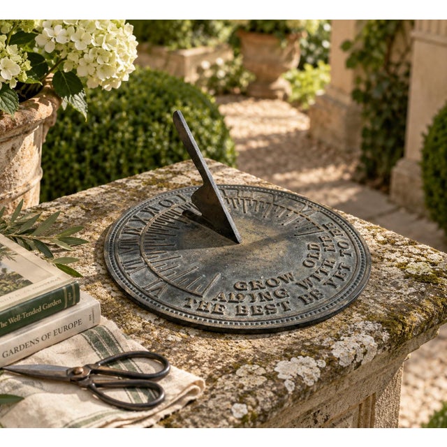 A classic vintage iron verdigris garden sundial, inspired by traditional English estate landscapes, reading "Grow old...