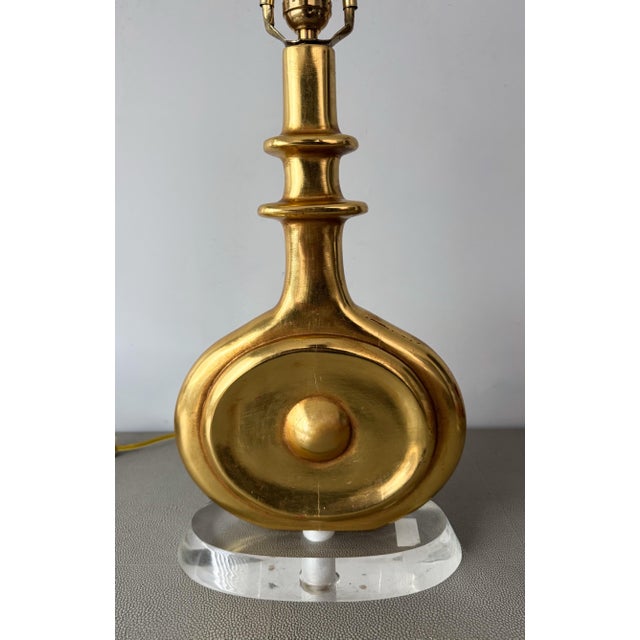 Fantastic, gilt wood table lamp mounted on an oval acrylic base. Real 24k gilding on this very modernist design. I did not...