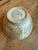 In the style of a Hagi ware pottery bowl, a traditional Japanese ceramic style: The bowl features a creamy, off-white...
