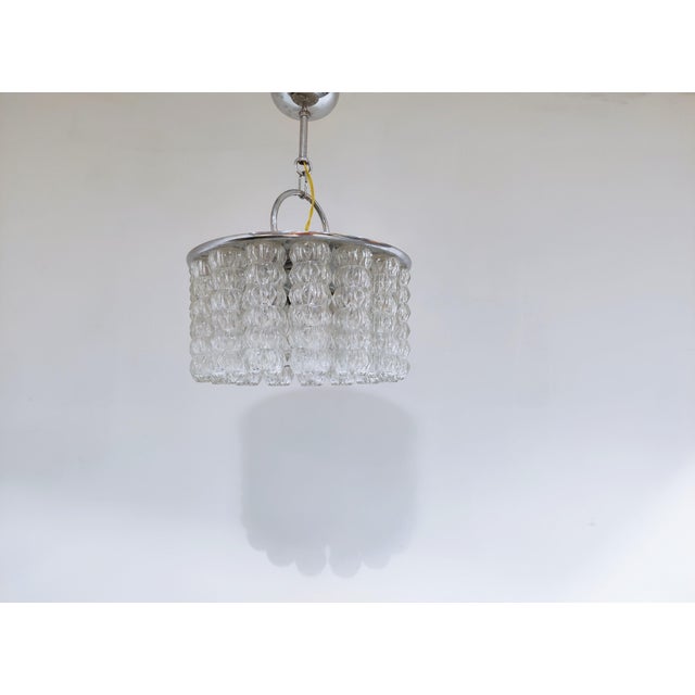 Mid century chandelier with linked glass lamp shades and chrome. The lamp emits a beautiful light. Good condition. Works...