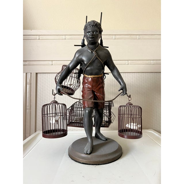 Vintage metal "Blackamoor" Bird Seller statue made by Petites Choses. A highly detailed, muscular figure depicted as a...
