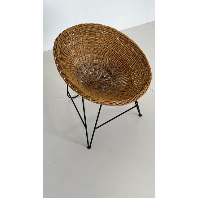 A prized design classic. Comfortable wicker armchair, cone-shaped and woven from willow, with an elegantly curved, black...