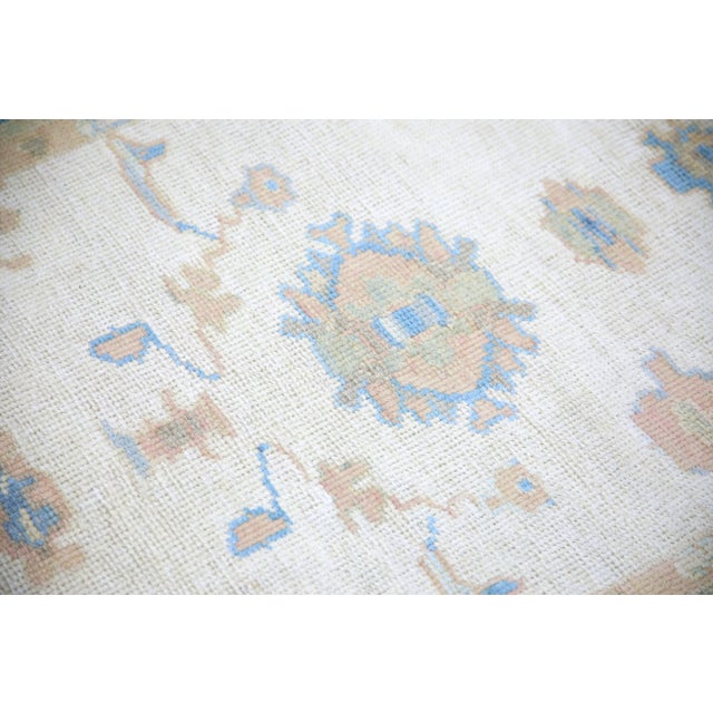 This modern Turkish Oushak rug is a stunning piece of art that has been handwoven using traditional techniques by skilled...