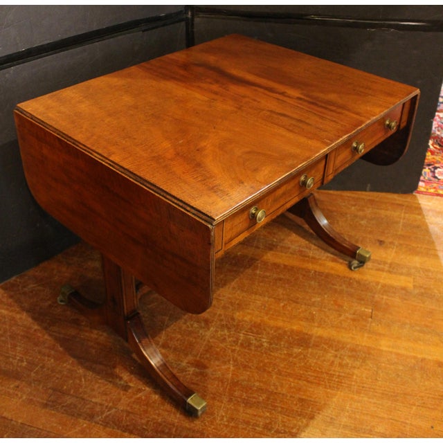 Circa 1810 Regency period sofa table, English. Restrained, elegant design of fine mahogany with ebony inlays. Finely...